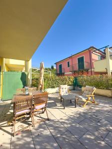 a patio with two benches and a table and chairs at Riviera Charme House in San Bartolomeo al Mare