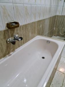 a white bath tub in a bathroom at Pyramids Heritage suites in Ghaţāţī