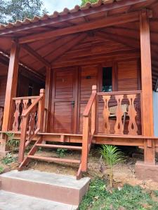 a wooden house with a wooden railing and stairs at Naraya Nusantara Resort & Kafe in Sepaku