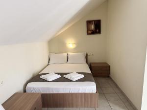 a small bedroom with a bed and a wooden table at ANNA ROOMS (Villa Anna) in Nea Vrasna