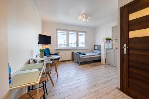 a living room with a table and chairs and a door at Apartament Szczecin Kobalt – Brama Portowa in Szczecin