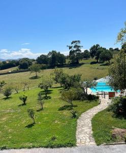 a view of a pool from a hill with trees at Caserio EL AJO in Herrán