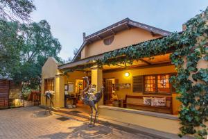 een huis met twee standbeelden ervoor bij Riverside Guest Lodge in Oudtshoorn