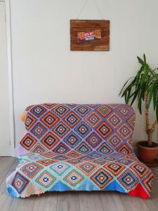 eine Couch mit einer bunten Decke auf einem Zimmer in der Unterkunft Rabbit Haven- Near Bicester Village & Town - ShireStays in Bicester