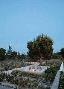 a fire pit in the middle of a field with a tree at Spatia Comporta in Comporta