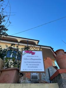 a sign in front of a building with a pot at Villa le Bougainvillea in La Maddalena