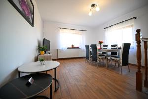 a living room with a dining room table and chairs at Casa MonyBeea in Silvaşu de Sus