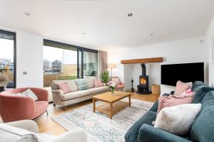 a living room with two couches and a fireplace at Minety Lake 64 ML64 Lower Mill Estate Cotswolds in Somerford Keynes