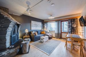 a living room with a blue couch and a fireplace at Lodge 67°N Lapland in Äkäslompolo
