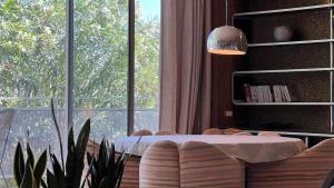 un salon avec une table et une grande fenêtre dans l'établissement Le Seventies, à Bouzigues