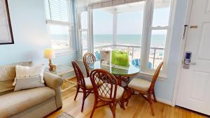 a living room with a table and chairs and a couch at Folly Beach Suites 3A in Folly Beach