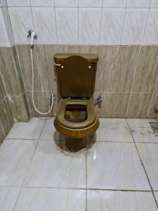 a bathroom with a toilet with a brown seat at Pyramids Heritage suites in Ghaţāţī +18 photos