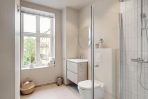 une salle de bain blanche avec toilettes et douche dans l'établissement Dinbnb Apartments Grünerløkka I 2-Bedroom with courtyard access, à Oslo 39 autres photos