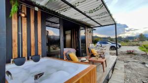 eine große Badewanne auf einer Terrasse mit Aussicht in der Unterkunft Romántico Glamping tipo contenedor con Jacuzzi cerca al lago de Paipa in Paipa