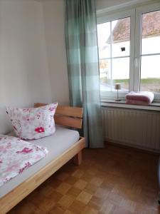 a small bedroom with a bed and a window at Ferienwohnung Ida in Staig