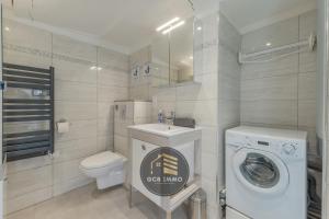 a bathroom with a washing machine and a toilet at Chez Mumu 2 chambres cosy in Grenoble