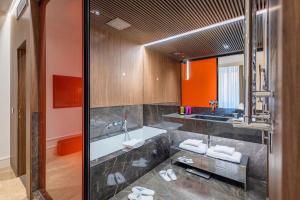 a bathroom with a tub and a sink at The First Dolce - Preferred Hotels & Resorts in Rome