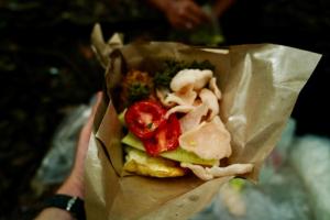 a person holding a sandwich in a paper bag at Sama Sama Homestay & Trekking Only Stay Here Book Trekking and Transport With Us in Bukit Lawang +139 photos