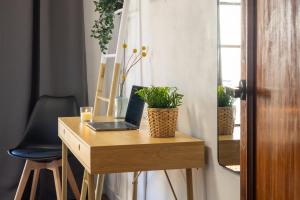 a desk with a laptop on it with plants on it at Nordik Rooms Village - Torremolinos "Undredal" in Torremolinos