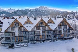 扎科帕内Aparthotel Prestige & SPA的山中一座公寓楼