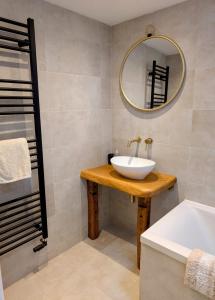 a bathroom with a sink and a mirror and a tub at Ramble & Rye - The Nest in Talland +12 photos