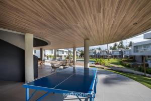 - une table de ping-pong sur une terrasse dotée d'un plafond en bois dans l'établissement NLU - Condomínio completo na Praia do Marceneiro, à Barra do Camaragibe