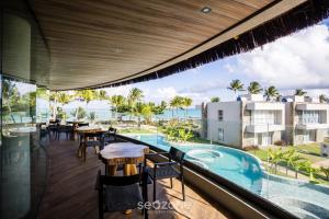une vue depuis le balcon d'un complexe hôtelier avec piscine dans l'établissement NLU - Condomínio completo na Praia do Marceneiro, à Barra do Camaragibe