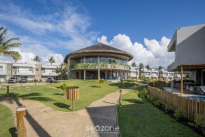 un grand bâtiment avec une cour en gazon devant lui dans l'établissement NLU - Condomínio completo na Praia do Marceneiro, à Barra do Camaragibe
