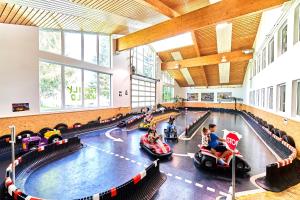 un gruppo di bambini che cavalca su auto giocattolo in palestra di Ferienwohnung Bayerwald-Blick, Schwimmbad, Sauna a Sankt Englmar Altre 46 foto