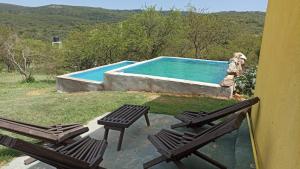 a swimming pool with two chairs and a swimming pool at vistas del valle casa amarilla in Valle Hermoso