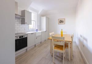 a kitchen with a wooden table and a dining room at The Bakers House in Elie