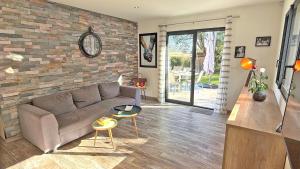 a living room with a couch and a brick wall at Villa Pré d'Icard in Plan-de-la-Tour