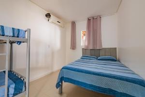 un dormitorio con una cama y una litera en Casa confortavel com churrasqueira, rede e Wi-Fi, en Mata de Sao Joao