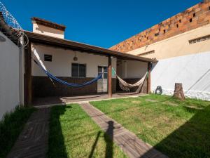 un patio con una hamaca fuera de un edificio en Casa confortavel com churrasqueira, rede e Wi-Fi, en Mata de Sao Joao