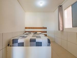 Un dormitorio con una cama en una habitación blanca. en Casa confortavel com churrasqueira, rede e Wi-Fi, en Mata de Sao Joao 21 fotos más