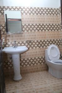 a bathroom with a sink and a toilet and a mirror at Royal Tree Hotel in Lahore