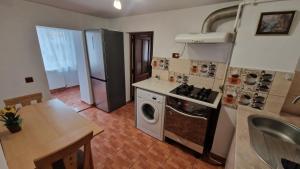 a kitchen with a stove and a refrigerator at Closca Apartment 1 Max in Floreşti