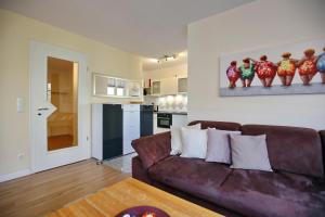 un salon avec un canapé marron et une cuisine dans l'établissement Villa Seepferdchen Wohnung 07, à Kühlungsborn 12 autres photos