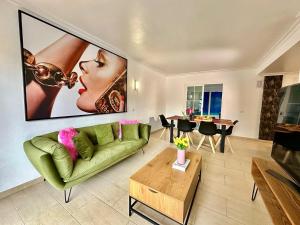 a living room with a green couch and a table at Villa Dolce Vita lujo in Puigderrós
