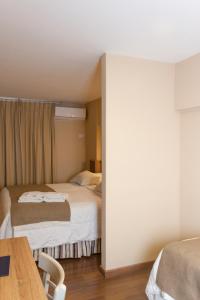 a hotel room with two beds and a table at Hotel Mediterraneo in San Miguel de Tucumán +40 photos