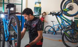 a man working on a bike in a garage at Lobios Caldaria Hotel Balneario in Bubaces