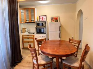 Una cocina con una mesa de madera y una mesa y sillas. en Cozy Central Apartment Steps from Everything!, en Varna