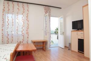 a room with a bed and a table and a television at The Korčula Outlook - Bedrooms in Korčula