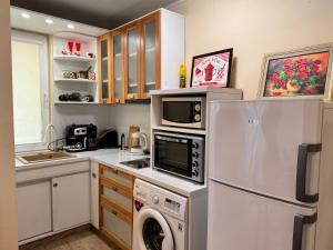una cocina con refrigerador y lavadora y secadora en Cozy Central Apartment Steps from Everything!, en Varna