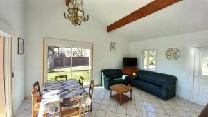 a living room with a table and a couch at Villa ravissante à Loubressac avec piscine privée in Loubressac