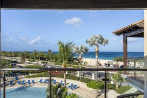 a view of the beach from the balcony of a resort at Beachfront - Eagle Beach - Sapphire 2BR condo E322 in Palm-Eagle Beach