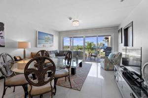a dining room and living room with a table and chairs at Beachfront - Eagle Beach - Sapphire 2BR condo E322 in Palm-Eagle Beach