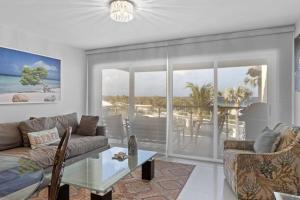 a living room with a couch and a glass table at Beachfront - Eagle Beach - Sapphire 2BR condo E322 in Palm-Eagle Beach