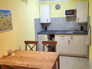 a kitchen with a wooden table and a kitchen with a sink at Ferienwohnung Ackermann in Ribnitz-Damgarten