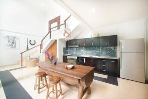 a kitchen with a wooden table and a refrigerator at Villa Penelopy in Seminyak